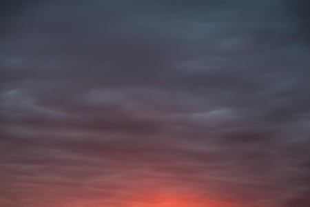 Dramatic skyscape background. The sky with dark clouds in front of a thunderstorm with a fiery glow.の写真素材