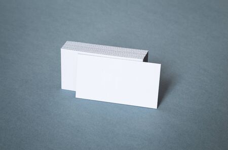 Blank white business cards with shifted front card on a gray backgroundの写真素材