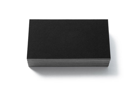 Blank black business card isolated on white background. Front view. Standard size. Stylish textured stack of cardboard for personal advertising or corporate design.の写真素材