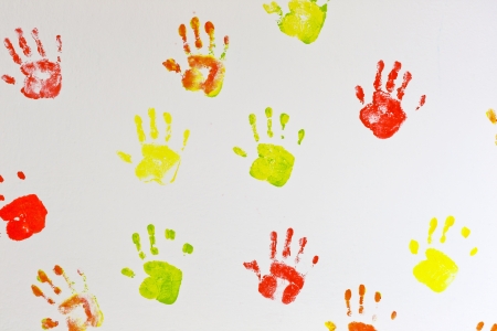 Kids hands prints on the wall backgroundの写真素材