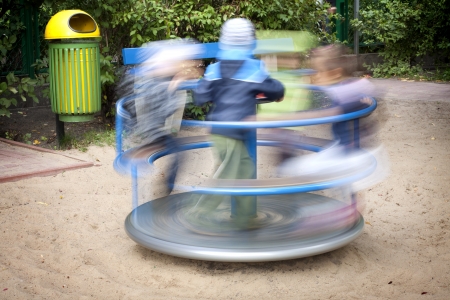 	Carousel in motion and happy kids on playgroundの写真素材