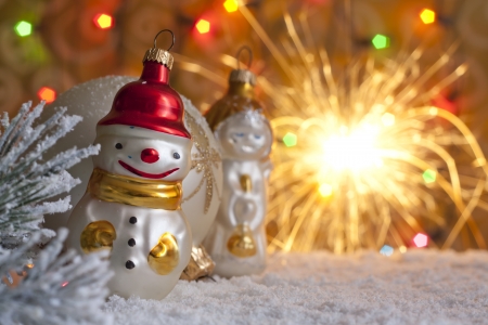 Snow man and blurred christmas background with sparklersの写真素材