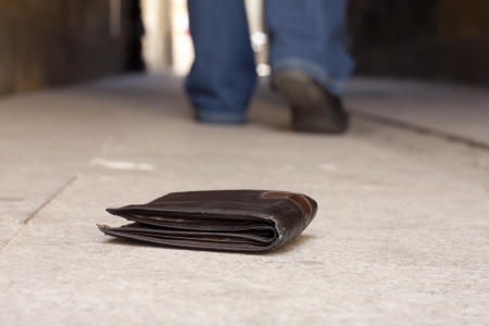 Lost wallet on the street and legs of the walking man conceptの写真素材