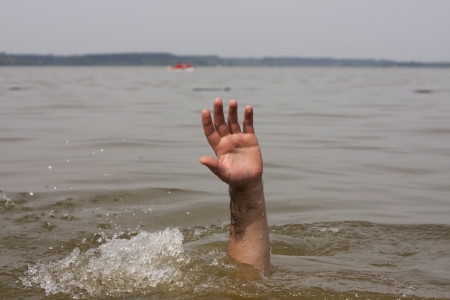 Hand of drowning man waits for help in the lakeの写真素材