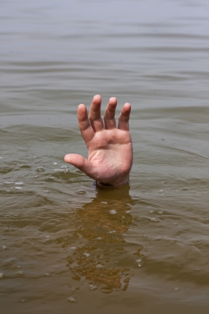 Hand of drowning man waits for help in the lakeの写真素材