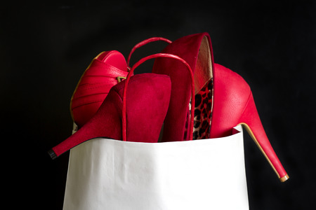 High heels red shoes in shopping bag against blackの写真素材