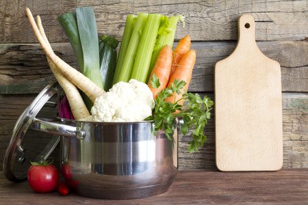 Fresh vegetables in the pot on vintage boards cooking conceptの写真素材