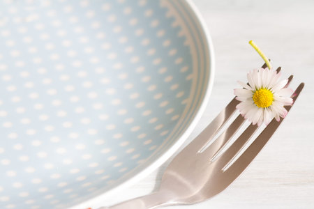 Spring food abstract background with daisy on the fork