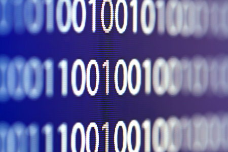 Binary code on a computer monitor blurred background