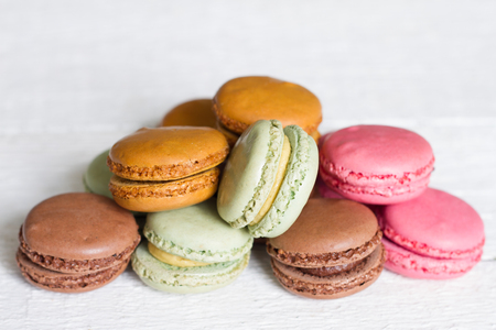 Colorful macarons, macaroons cake on white wooden background closeupの写真素材