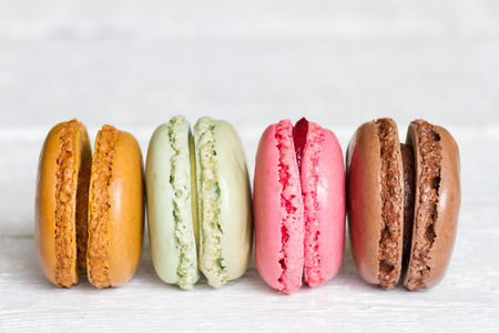 Colorful macarons, macaroons cake on white wooden background closeupの写真素材