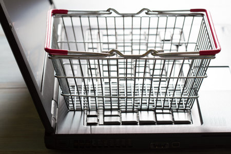 Shopping basket on laptop buying online abstract background conceptの写真素材
