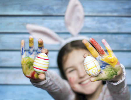 Smiling little girl with colored easter eggsの写真素材