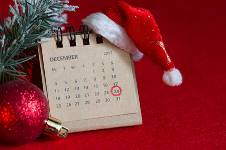 Calendar and circled christmas date on red background with santa claus hatの写真素材