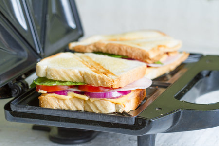 Sandwich toaster with toast and ingredients