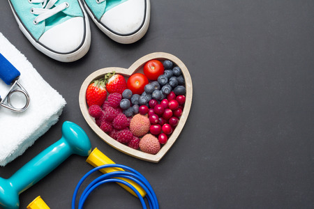 Healthy heart diet and sport gym equipment concept on blackboardの写真素材