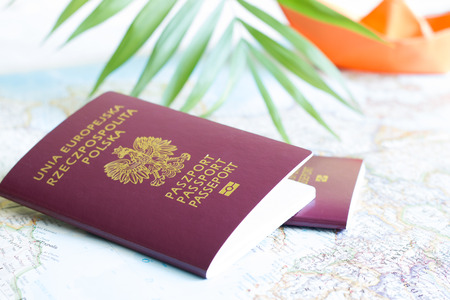 Polish passport and holiday travel concept with map and paper boatの写真素材