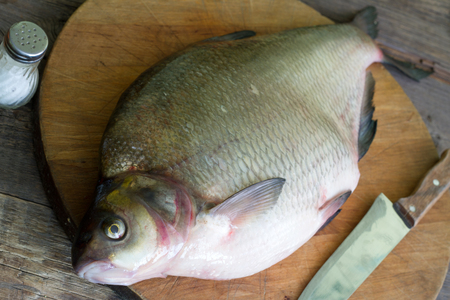 Raw river bream fish on the kitchen before scrapingの写真素材