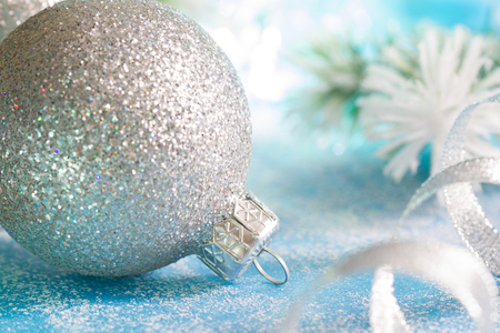 Abstract christmas background with silver bauble and snow blue backgroundの写真素材