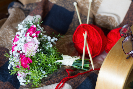 Grandmother's day concept with flowers and knitting on armchairの写真素材