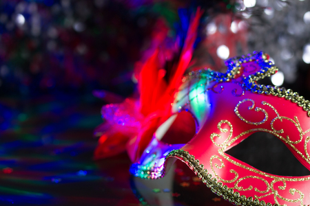 Venetian red mask on defocused carnival party backgroundの写真素材