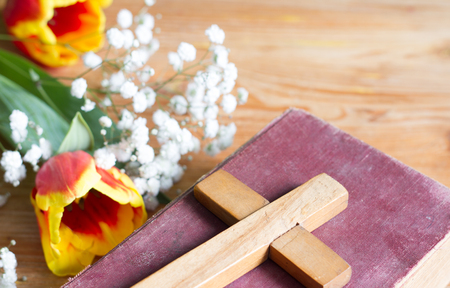 Spring easter flowers and cross on wooden backgroundの写真素材