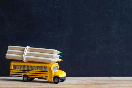 Back to school concept with bus and accessories on blackboard