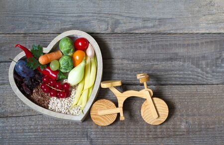 Healthy food in heart with stethoscope and bike diet sport lifestyle conceptの写真素材