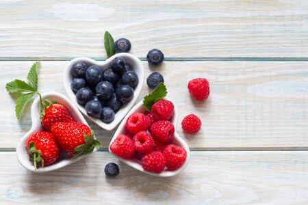 Raspberries blueberries and strawberry in the heart still lifeの写真素材