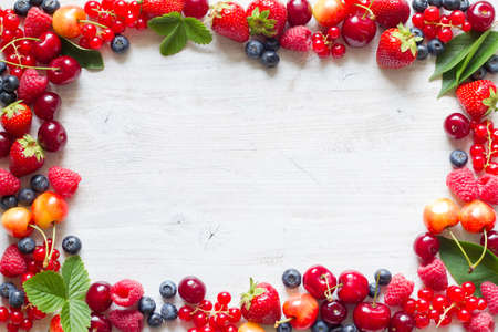 Frame with fresh summer berries mix, strawberries, raspberries, cherries, blueberries and currantsの写真素材