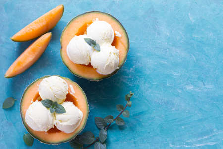 Delicious ice cream with mint leaf in melon halvesの写真素材