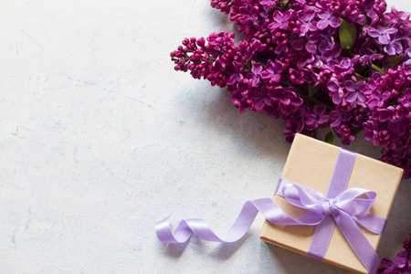 Gift box with lilac ribbon and lilacs flowersの写真素材