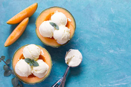 Delicious ice cream with mint leaf in melon halvesの写真素材