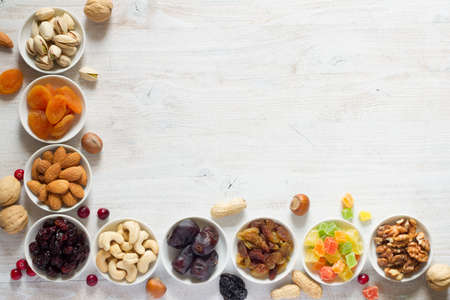 Mix of nuts and dried fruits in small bowls. Healthy and tasty snackの写真素材