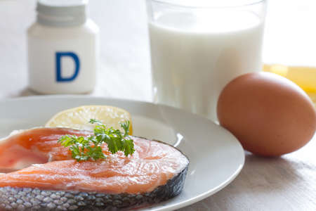 Salmon, milk, eggs and cheese, in background vitamin D. Natural sources of vitamin D and supplementの写真素材