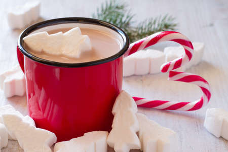 Mug of Christmas cocoa with marshmallows in shape Christmas trees and candy canesの写真素材