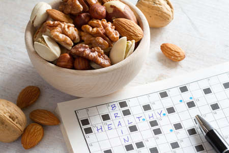 Crossword with "healthy brain" password and mix of nuts in bowl, efficient brain and good memory conceptの写真素材