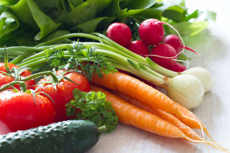 Assortment of fresh spring vegetables on white wooden backgroundの写真素材