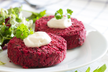 Vegetarian beetroot burgers with garlic sauce and fresh mixed saladの写真素材