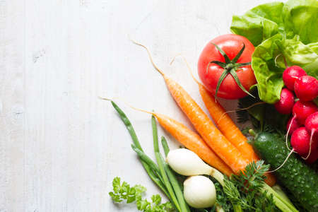 Assortment of fresh spring vegetables on white wooden backgroundの写真素材