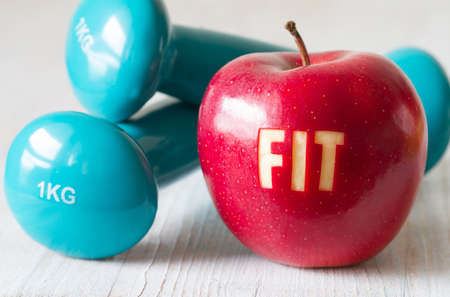 Red apple with word FIT and dumbbells, healthy diet and sport conceptの写真素材