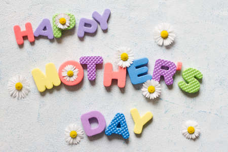 Lettering happy mother's day. Mother's day composition with colorful letters and daisiesの写真素材