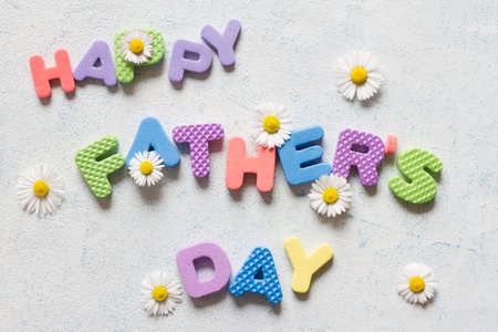 Lettering happy father's day. Father's day composition with colorful letters and daisiesの写真素材