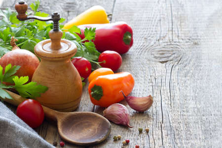 Wooden spoon, pepper mill and ingredients food on old boards backgroundの写真素材