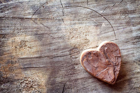 Carved wooden heart on old wood. Love background, free spaceの写真素材