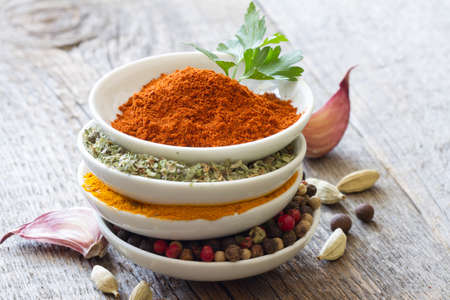 Herbs and spices in bowls on wooden boards backgroundの写真素材