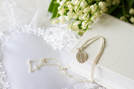 First Holy Communion with sacred medal on chain and flowers, concept background