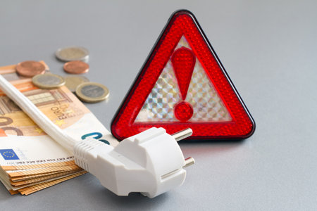 Warning sign with power plug and money, concept of rising energy pricesの写真素材