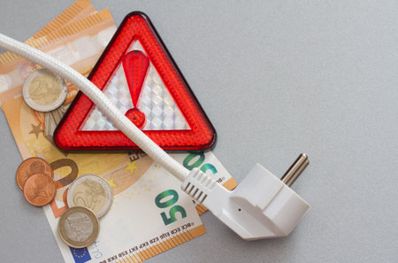 Warning sign with power plug and money, concept of rising energy pricesの写真素材