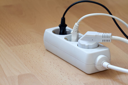 Electric extension cord with power plugs on floorの写真素材